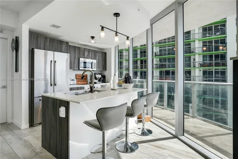 a dining room with stainless steel appliances granite countertop a refrigerator and a sink