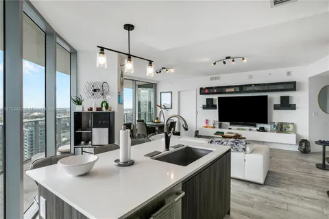 a kitchen with a sink a counter top space and stainless steel appliances