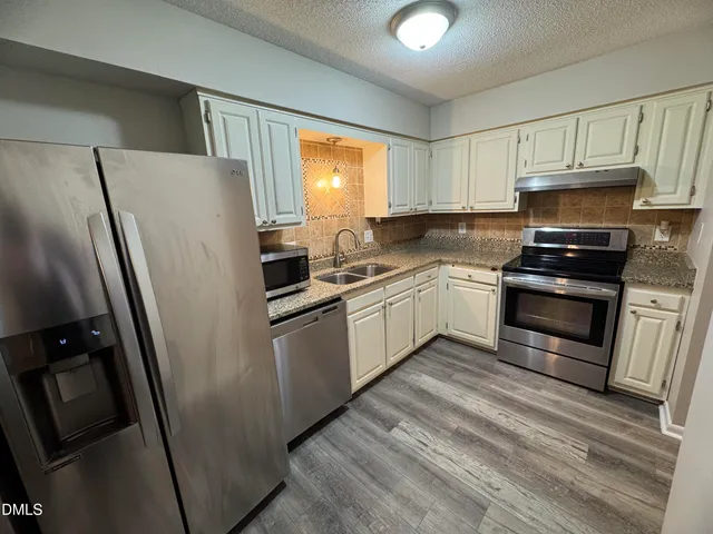 a kitchen with stainless steel appliances a refrigerator sink and microwave