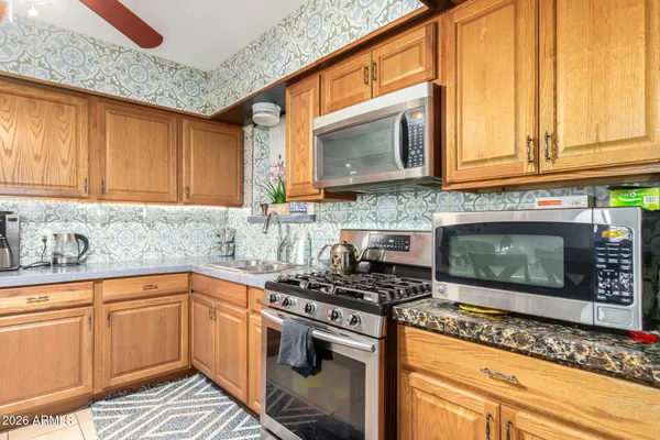a kitchen with stainless steel appliances granite countertop a stove a sink and a microwave