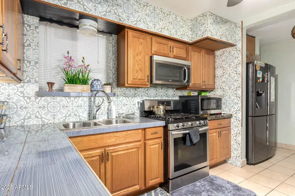 a kitchen with stainless steel appliances granite countertop a stove a sink and a microwave