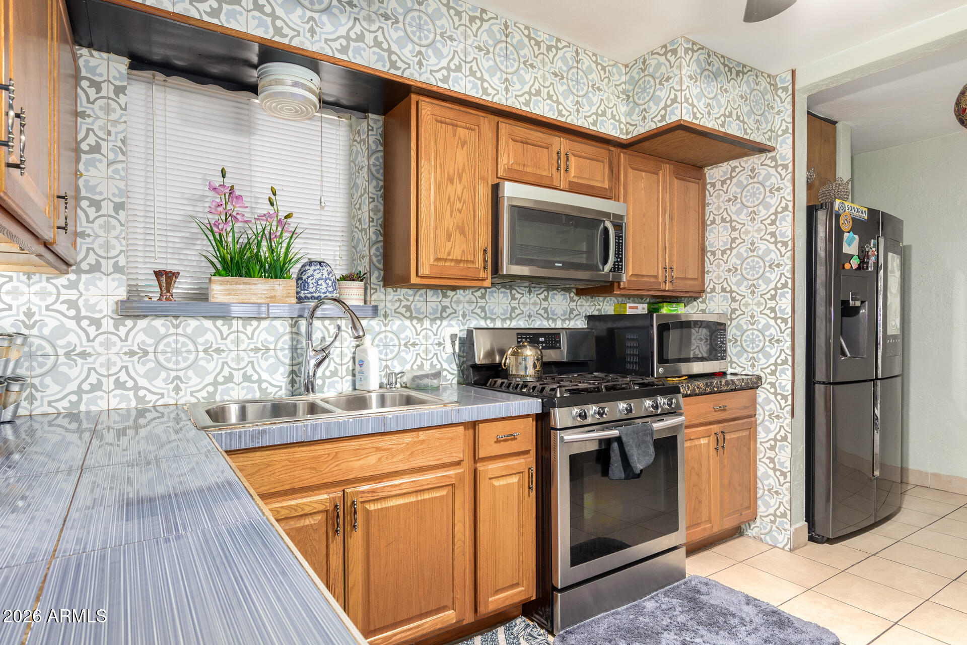2825 North 33rd Place Phoenix, AZ 85008 - Photo 13 of 27 a kitchen with stainless steel appliances granite countertop a stove a sink and a microwave