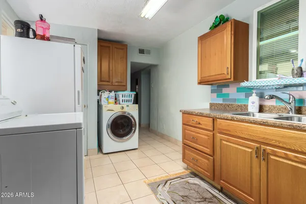 a utility room with sink dryer and washer