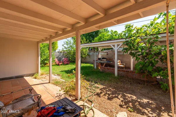 a view of a patio with table and chairs potted plants with wooden floor and fence