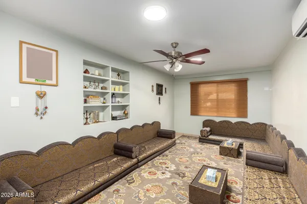 a living room with furniture ceiling fan and a window