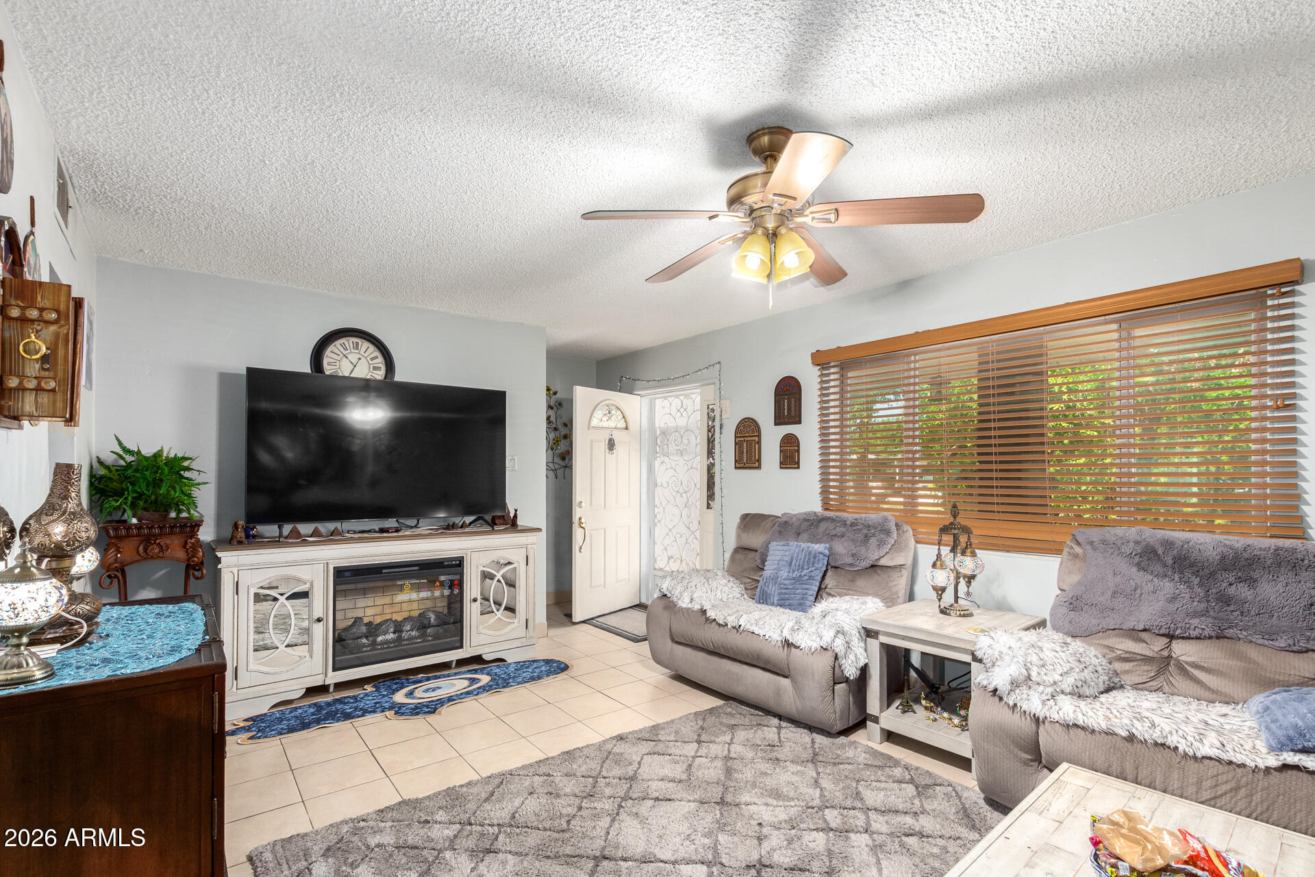2825 North 33rd Place Phoenix, AZ 85008 - Photo 7 of 27 a living room with furniture a flat screen tv and a fireplace