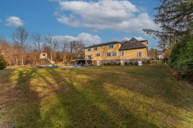 a view of a house with a big yard and large trees
