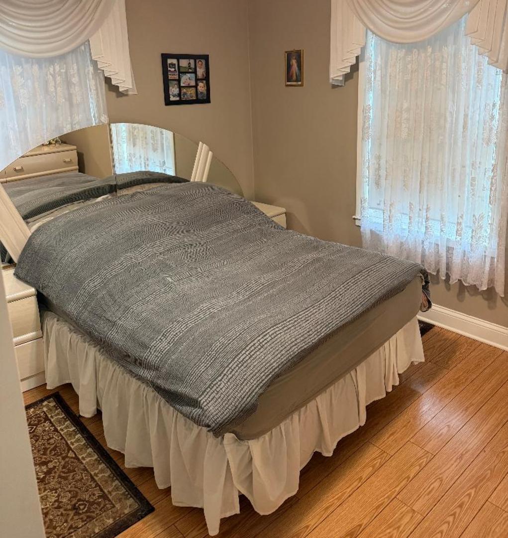 272 West Irving Park Road Wood Dale, IL 60191 - Photo 11 of 12 a spacious bedroom with a bed and wooden floor
