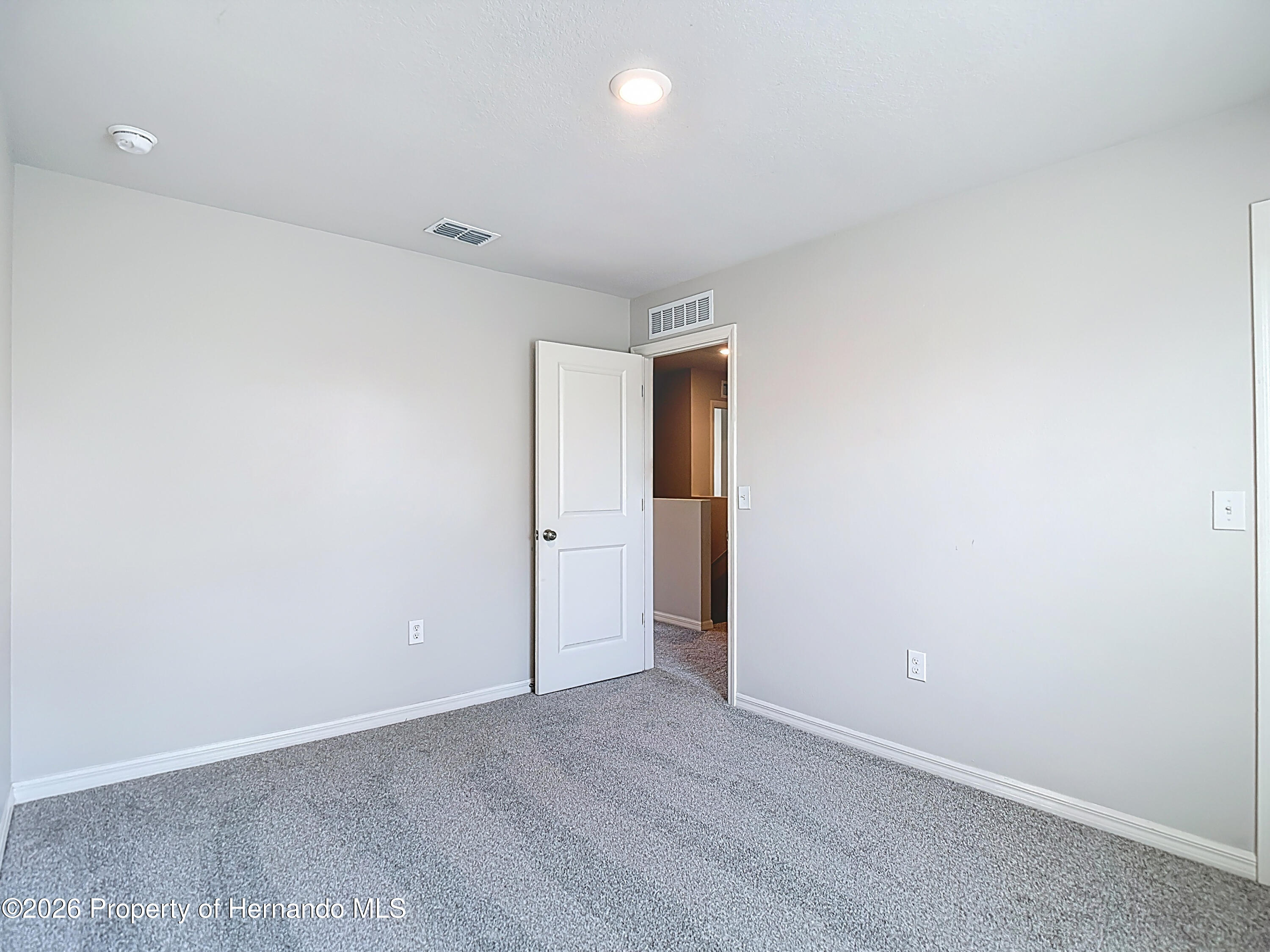 11374 Marcella Avenue Weeki Wachee, FL 34614 - Photo 51 of 70 an empty room with wooden floor and natural light