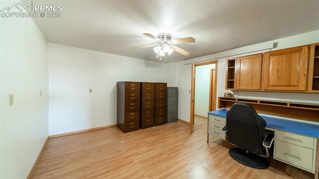 11125 Eureka Road Calhan, CO 80808 - Photo 37 of 44 Office space with built in desk, ceiling fan, light hardwood / wood-style flooring, and a textured ceiling