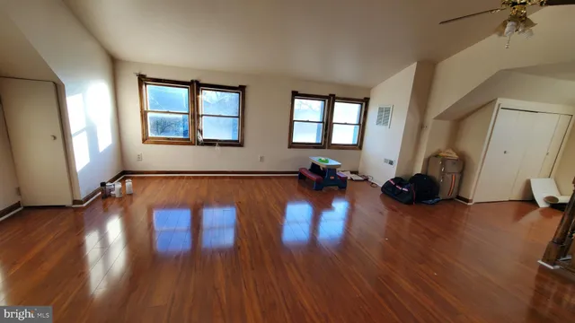 a view of empty room with wooden floor and windows