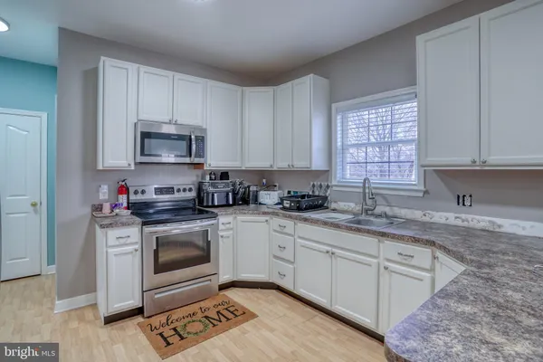 a kitchen with granite countertop a stove sink and refrigerator