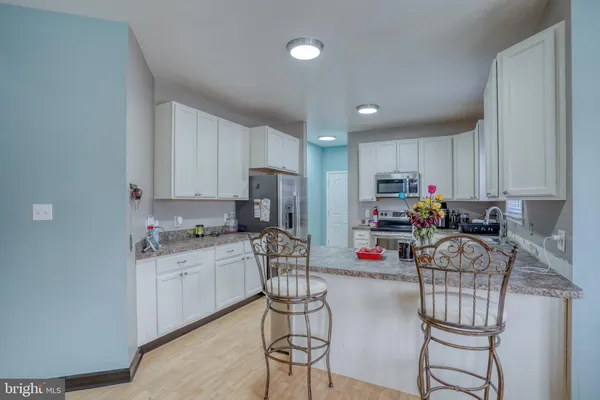 a kitchen with refrigerator and chairs