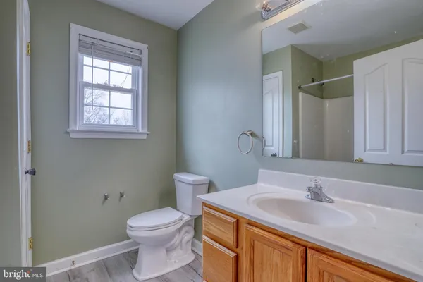 a bathroom with a granite countertop sink toilet and a mirror