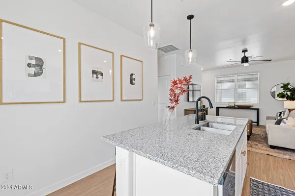 a kitchen with stainless steel appliances granite countertop a sink dishwasher a microwave oven a stove with granite countertop cabinets and wooden floor