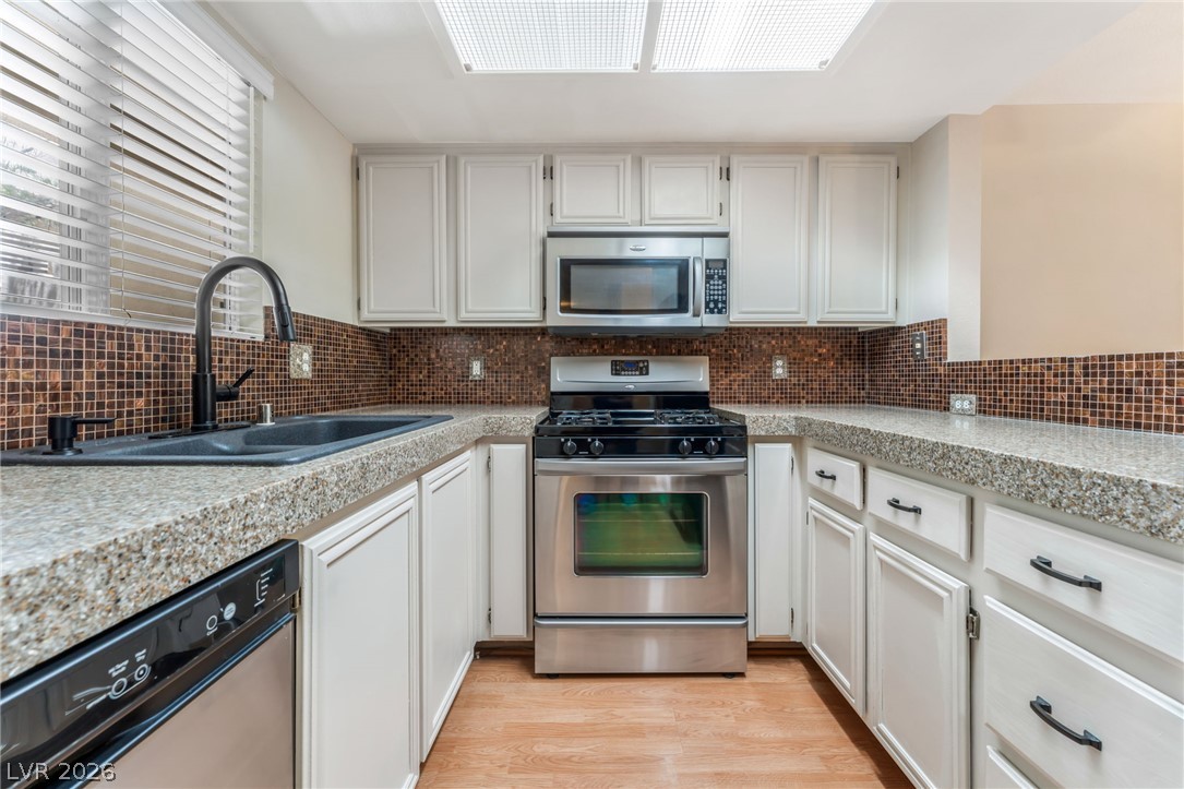 1901 Rio Canyon Court, Unit 102 Las Vegas, NV 89128 - Photo 5 of 23 Functional kitchen with ample counter space and appliances, ready for culinary endeavors.