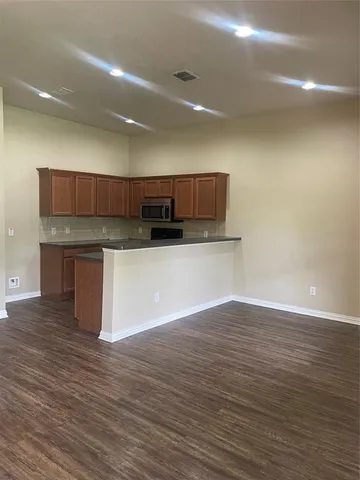 a kitchen with stainless steel appliances wooden cabinets and a wooden floor