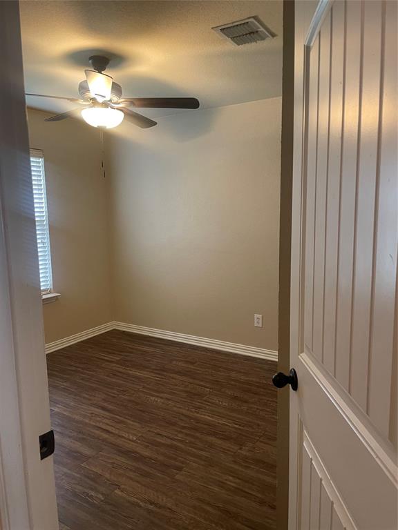 892 West First Street Maypearl, TX 76064 - Photo 9 of 18 wooden floor in an empty room with a mirror