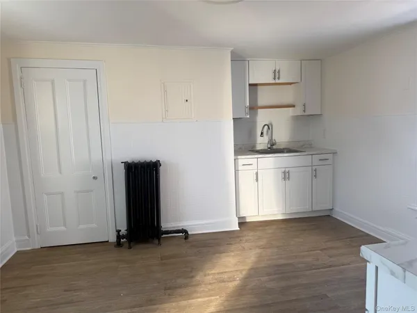 a view of kitchen with wooden floor and electronic appliances
