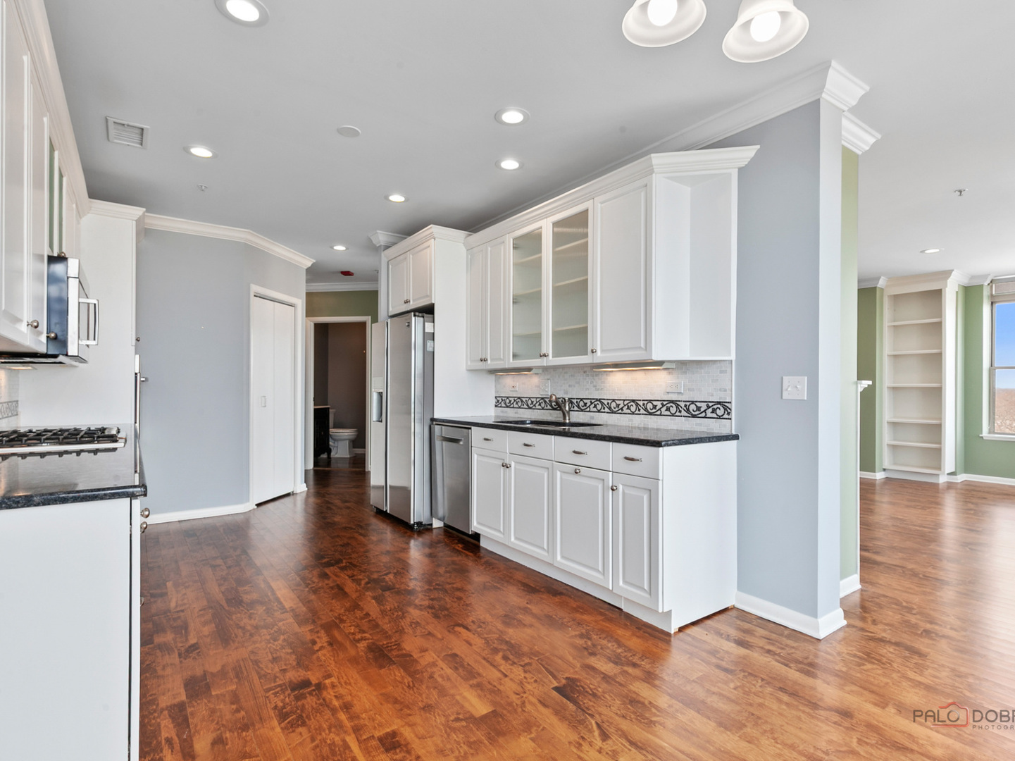 3535 Patten Road, Unit 6E Highland Park, IL 60035 - Photo 29 of 47 a open kitchen with granite countertop a stove top oven a sink dishwasher and a refrigerator with wooden floor