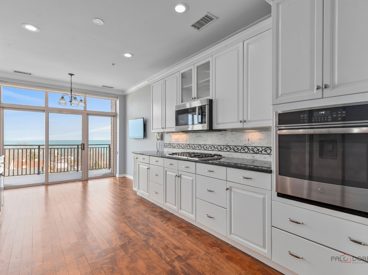 3535 Patten Road, Unit 6E Highland Park, IL 60035 - Photo 30 of 47 a large kitchen with granite countertop a stove top oven a sink and white cabinets with wooden floor