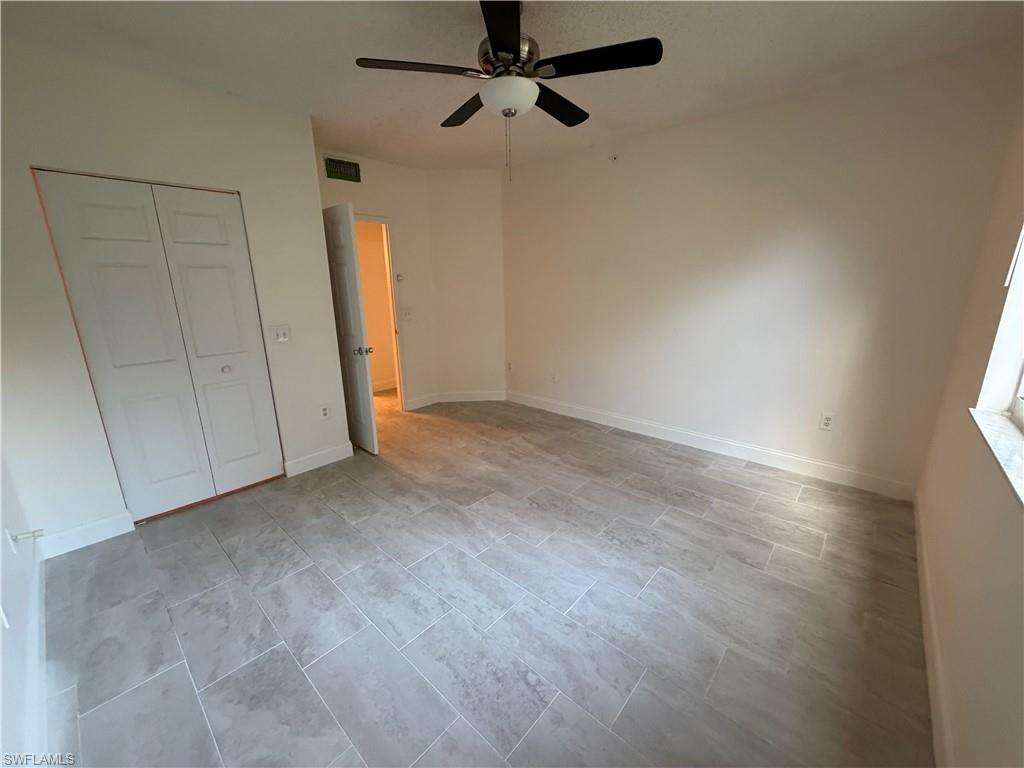1210 Reserve Way, Unit 9107 Naples, FL 34105 - Photo 12 of 22 an empty room with a ceiling fan and carpet