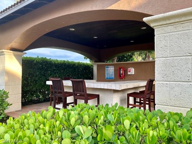 1210 Reserve Way, Unit 9107 Naples, FL 34105 - Photo 21 of 22 a view of a chairs and table in a patio