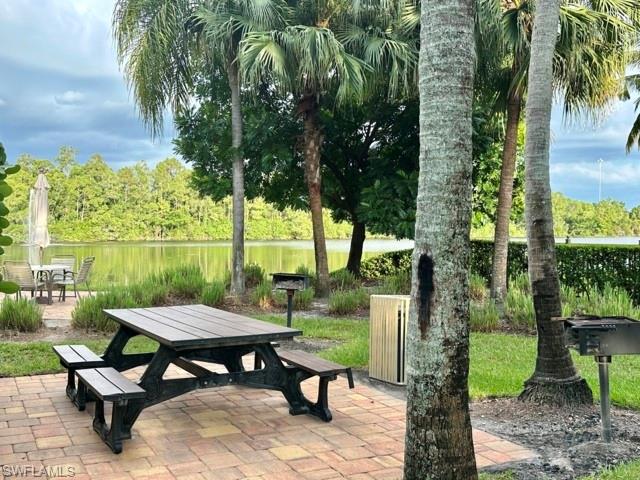 1210 Reserve Way, Unit 9107 Naples, FL 34105 - Photo 22 of 22 a view of a patio with table and chairs potted plants and palm tree