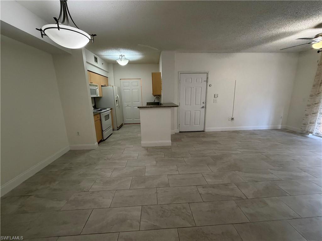 1210 Reserve Way, Unit 9107 Naples, FL 34105 - Photo 4 of 22 a view of a kitchen with a sink and dishwasher a refrigerator freezer