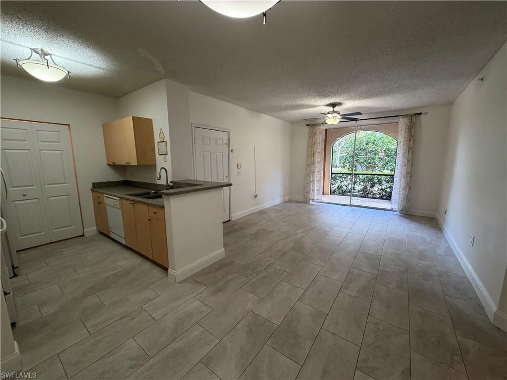 1210 Reserve Way, Unit 9107 Naples, FL 34105 - Photo 6 of 22 an empty room with windows and cabinet