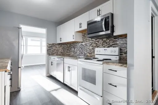 a kitchen with stainless steel appliances granite countertop a stove and a microwave