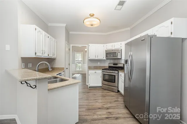 a kitchen with stainless steel appliances granite countertop a refrigerator stove and sink