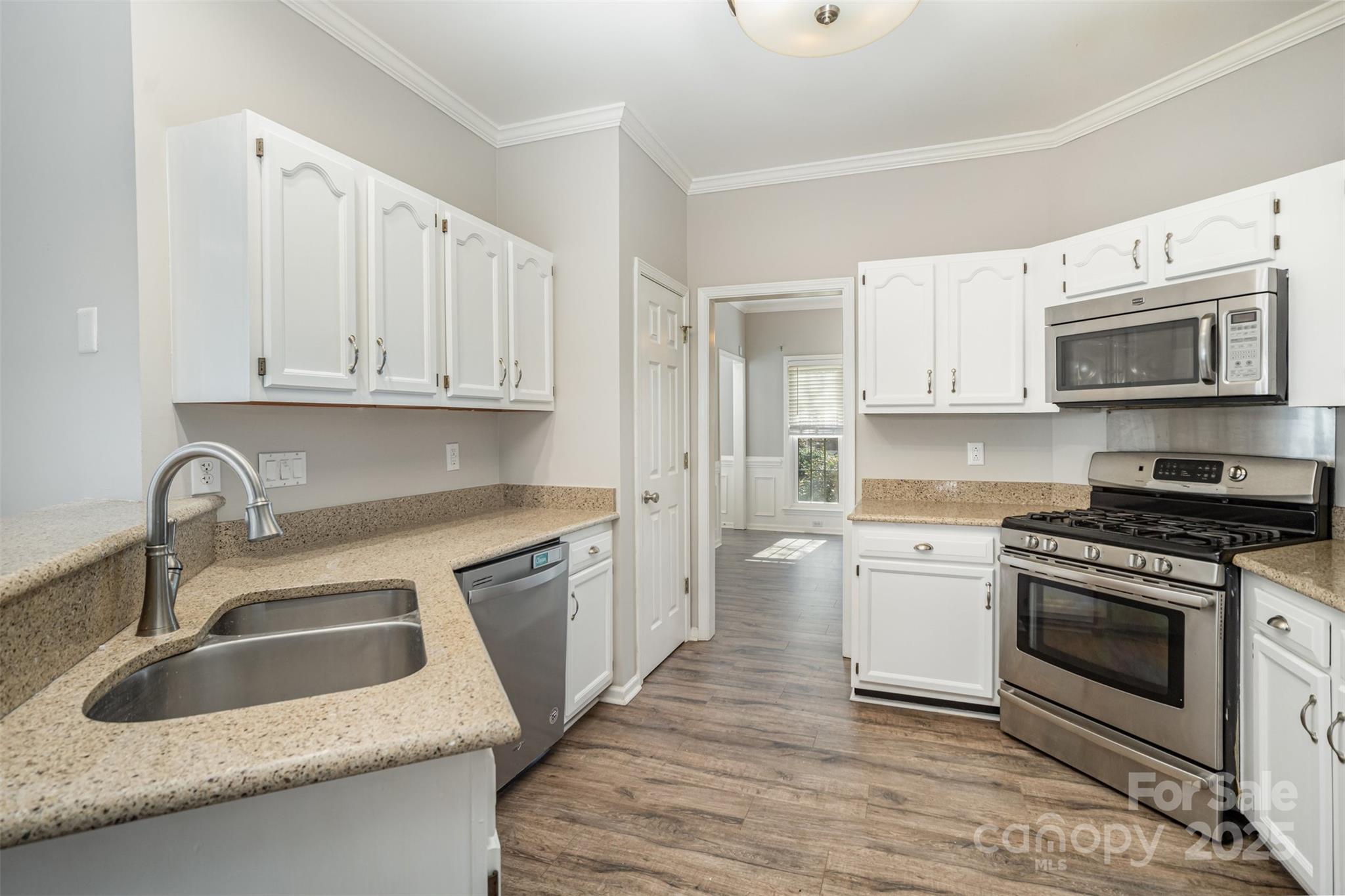 2507 Bathgate Lane Matthews, NC 28105 - Photo 12 of 36 a kitchen with granite countertop a sink a stove and cabinets