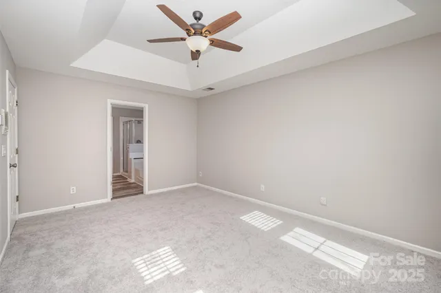 an empty room with a ceiling fan and a window