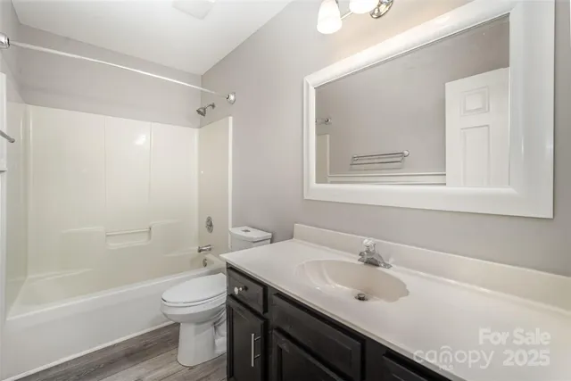 a bathroom with a sink toilet vanity and shower
