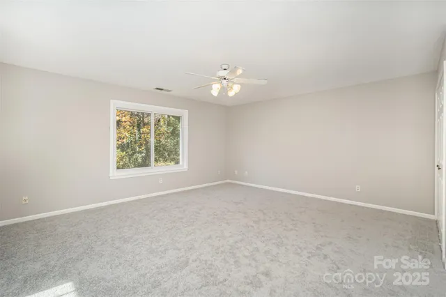 an empty room with a window and a ceiling fan