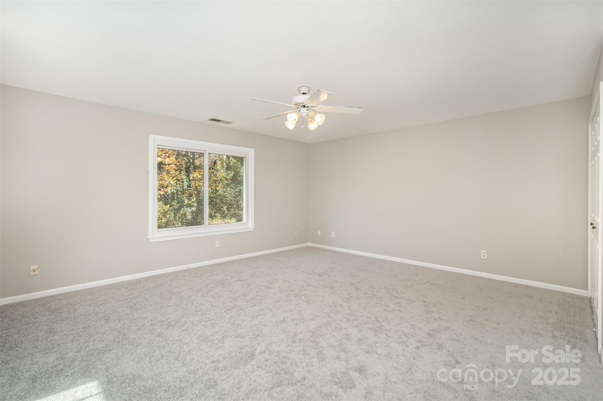 2507 Bathgate Lane Matthews, NC 28105 - Photo 29 of 36 an empty room with a window and a ceiling fan