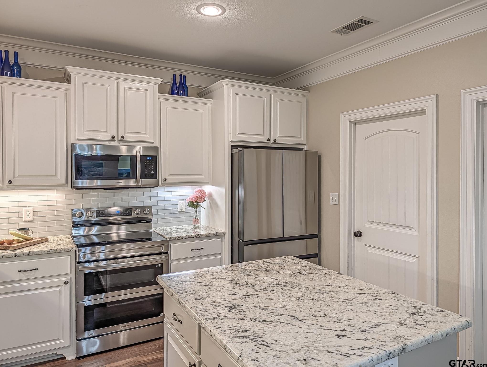 18488 Bluebird Circle Flint, TX 75762 - Photo 16 of 47 a kitchen with granite countertop a refrigerator stove and microwave