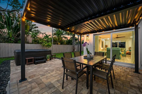a patio with table and chairs and potted plants