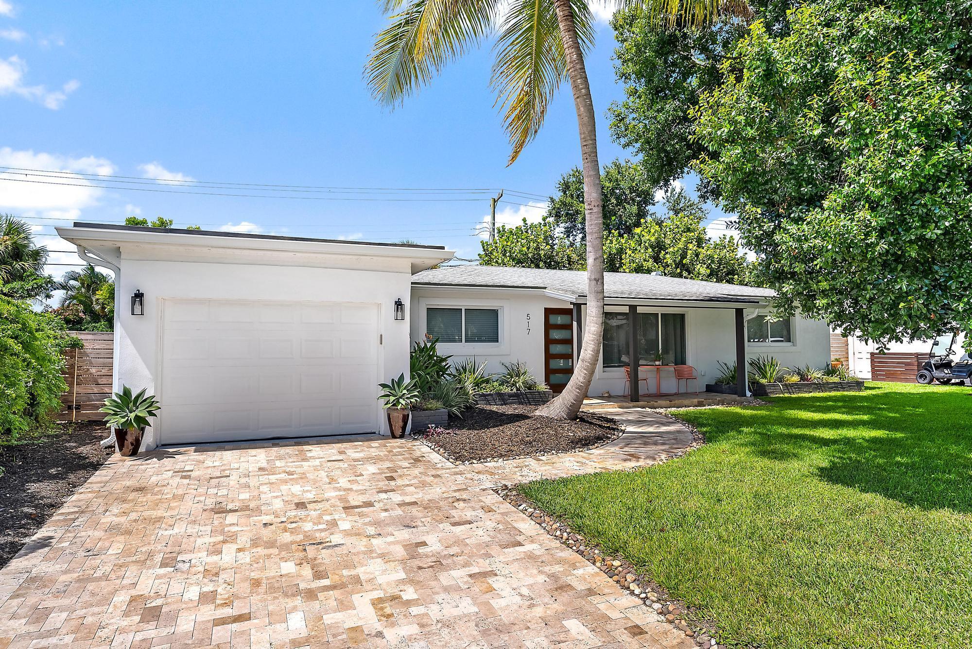 517 Gulf Road North Palm Beach, FL 33408 - Photo 5 of 59 a patio with a table and chairs under an umbrella