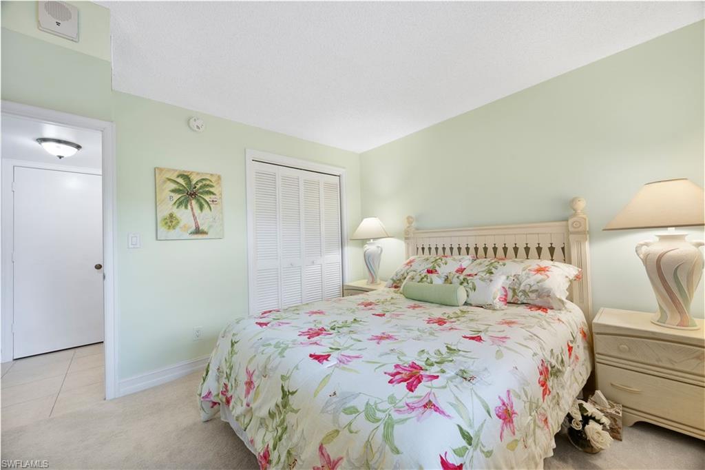 5683 Rattlesnake Hammock Road, Unit A202 Naples, FL 34113 - Photo 18 of 27 Bedroom featuring light carpet and a closet