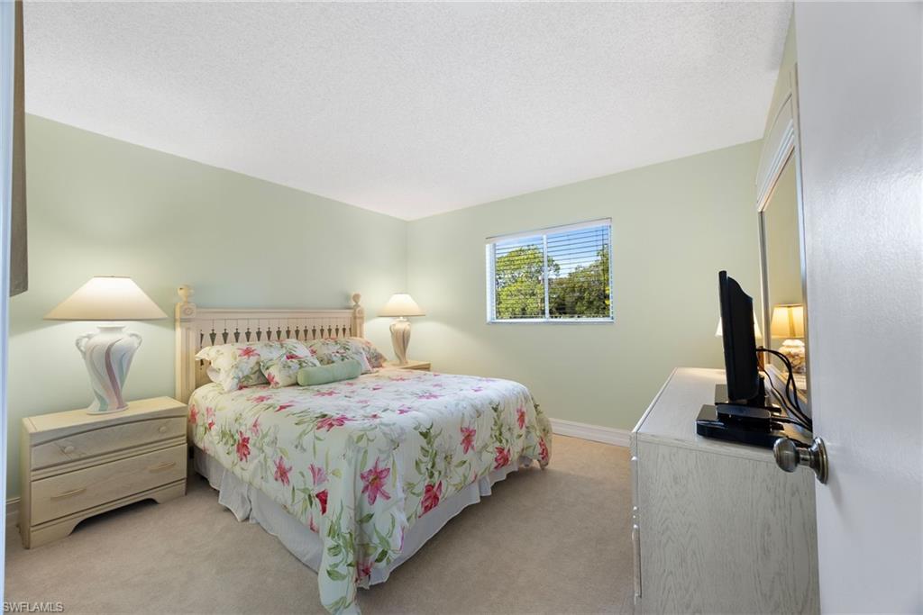 5683 Rattlesnake Hammock Road, Unit A202 Naples, FL 34113 - Photo 19 of 27 Carpeted bedroom with a textured ceiling and baseboards