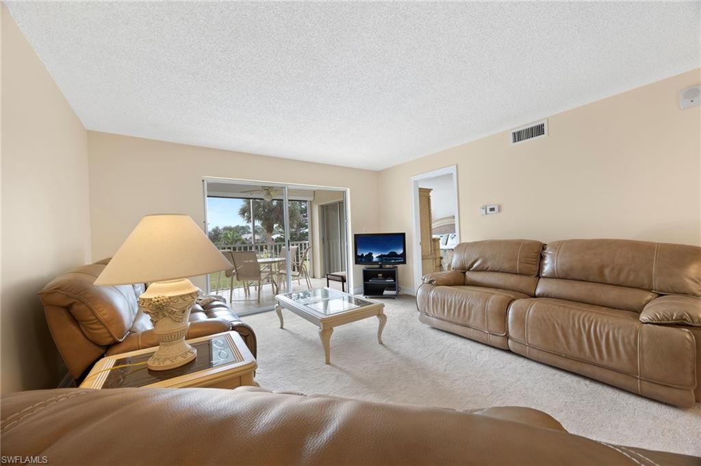 5683 Rattlesnake Hammock Road, Unit A202 Naples, FL 34113 - Photo 8 of 27 Living area with carpet and a textured ceiling