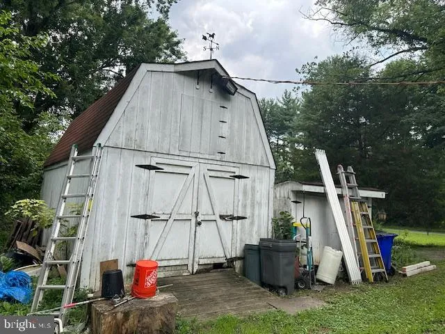 a view of wooden house with a yard and seating area