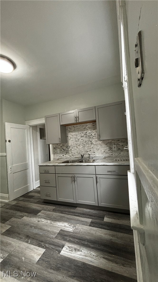 13421 Ashburton Road Cleveland, OH 44110 - Photo 6 of 28 Kitchen featuring gray cabinets, dark hardwood / wood-style floors, sink, and backsplash