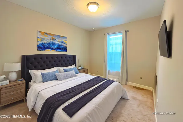 a bedroom with a bed and painting on the wall