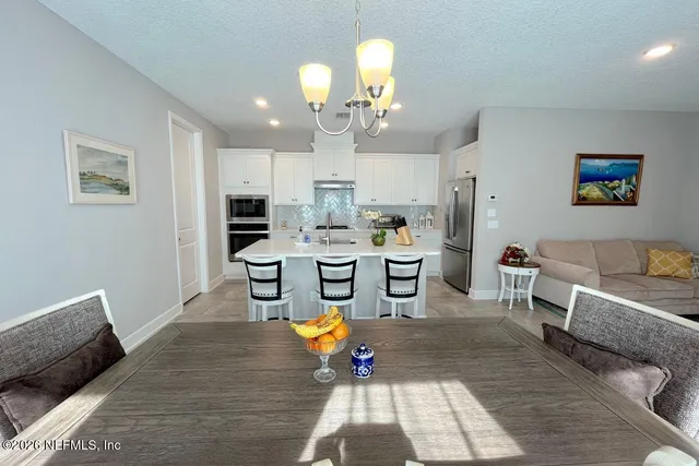 a living room with stainless steel appliances kitchen island granite countertop furniture and a rug