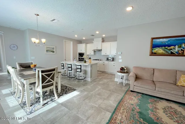 a living room with lots of furniture and a dining table with wooden floor