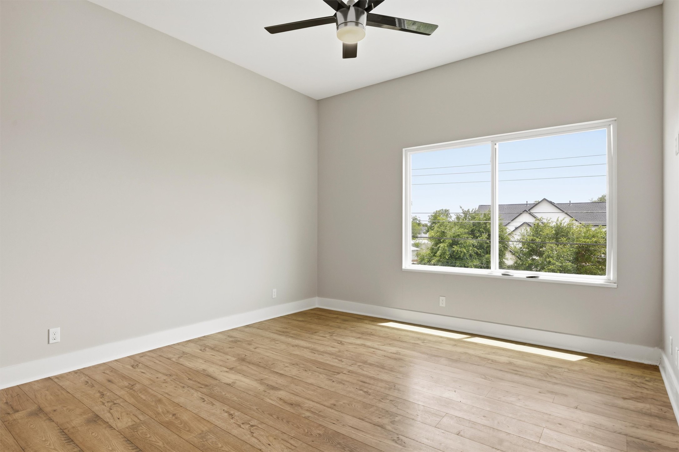1210 Stobaugh Street, Unit B Austin, TX 78757 - Photo 14 of 40 A naturally illuminated room features vaulted ceilings and rich hardwood flooring.