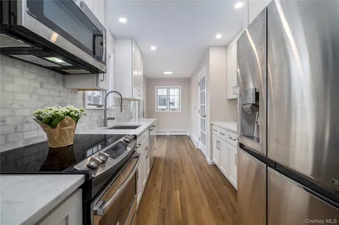 a kitchen with stainless steel appliances granite countertop hardwood floor sink stove and refrigerator